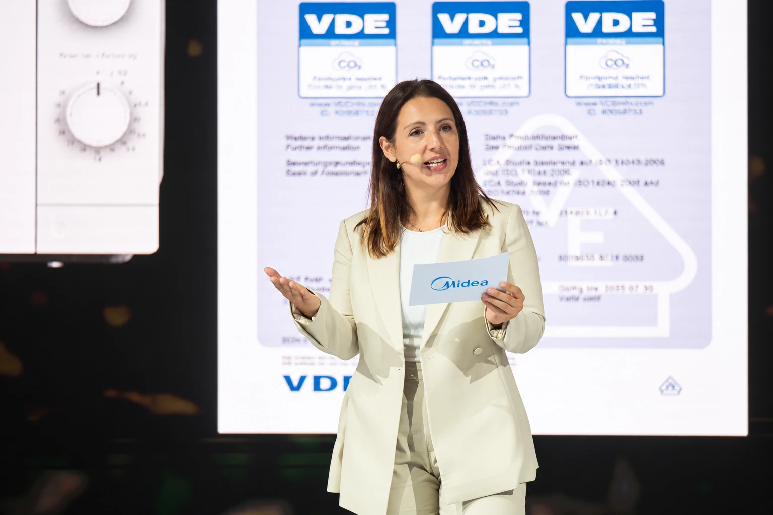 Dorothee präsentiert für Midea auf der IFA mit Headset und Moderationskarten